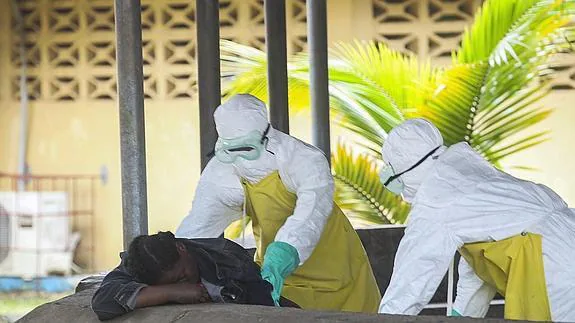 Dos enfermeros atienden a un enfermo de ébola.