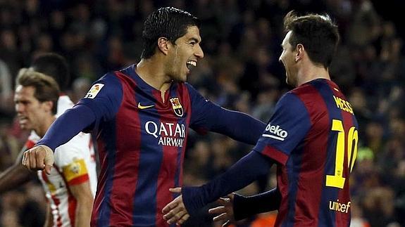 Luis Suárez (i) celebra un gol con Messi. 