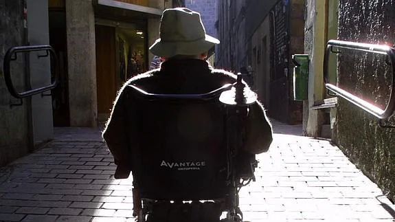 Una persona con discapacidad se desplaza con su silla de ruedas eléctrica.