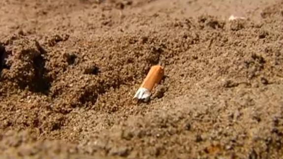 Una colilla en la arena.