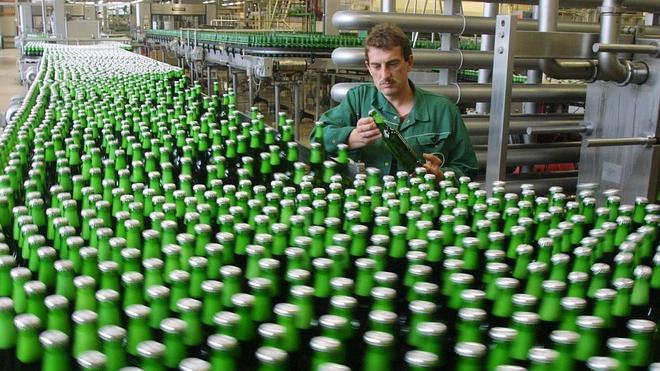 Un operario supervisa las botellas en una fábrica embotelladora de cerveza.