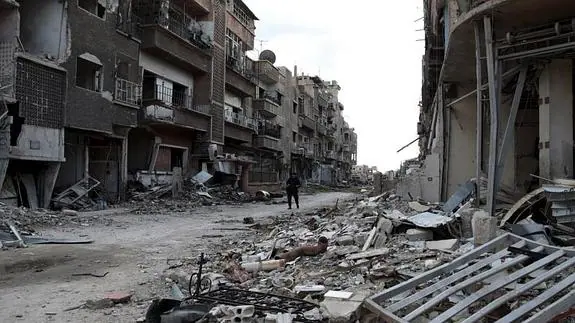 Un hombre camina por los edificios destrozados por los bombardeos en Jobar. 