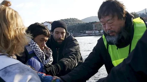 Ai Weiwei ayuda a refugiados afganos a su llegada a la isla de Lesbos. 