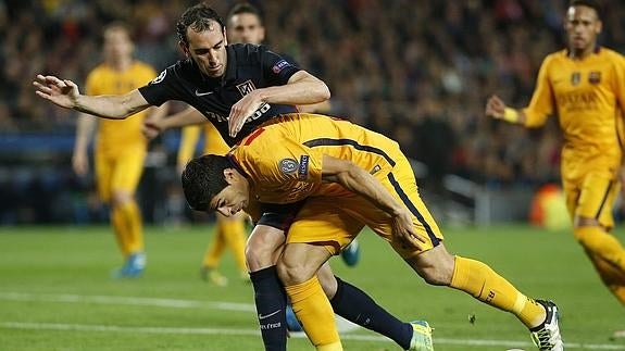 Godín y Suárez pugnan por un balón.