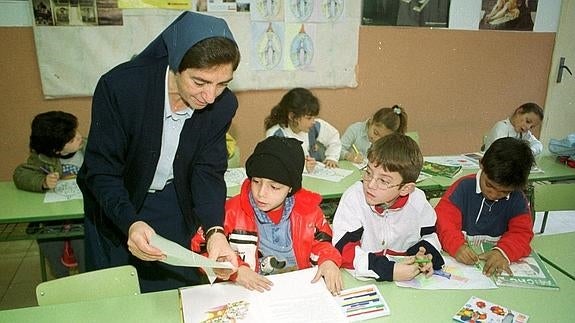 Una monja explicando una lección a unos alumnos.