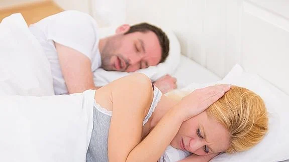 Una mujer no puede dormir mientras ronca su pareja. 