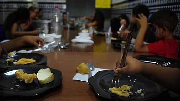 Niños pertenecientes a familias con escasez de recursos almuerzan en un comedor social.