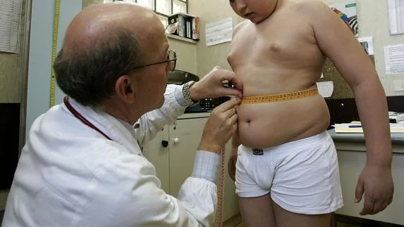 Un médico mide a un niño. 