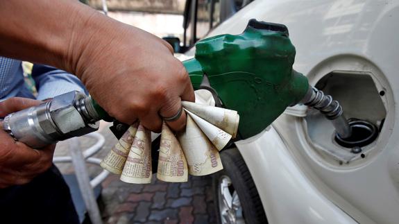 Un hombre reposta su vehículo diesel en una gasolinera.