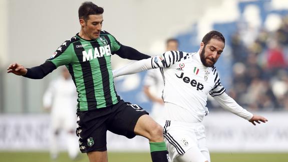 Higuaín pugna con Peluso. 