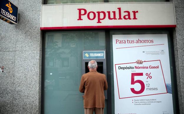 Un hombre usa un cajero automático del Popular. 