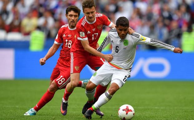 Jonathan Dos Santos, frente a dos futbolistas rusos. 