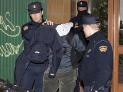 Agentes del Cuerpo Nacional de Policía trasladan a uno de los seis detenidos durante la madrugada del martes en Vitoria. /Efe