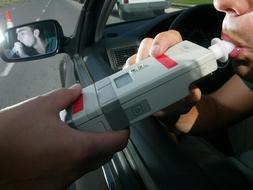 Un conductor sopla durante un control de alcoholemia realizado por la Policía Municipal en Vitoria./ Igor Aizpuru