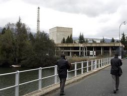 Dos personas atraviesan un puente junto a la Central Nuclear de Santa María de Garoña. /Avelino Gómez