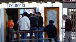 Varias personas en el exterior de un locutorio. / I. Aizpuru