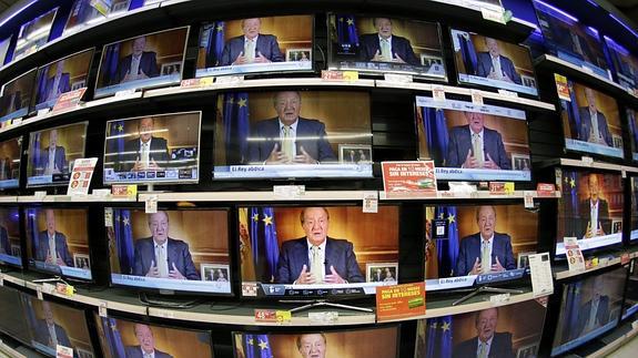 Varias televisiones de un centro comercial, emiten el mensaje institucional del Rey.