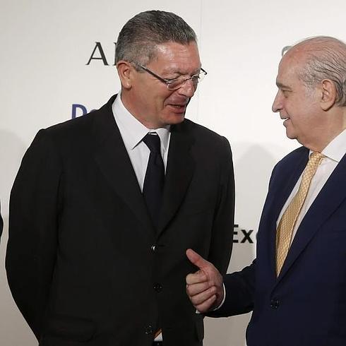 Fernández Díaz conversa con el ministro de Justicia, Alberto Ruiz-Gallardón, en un acto hoy en Madrid.