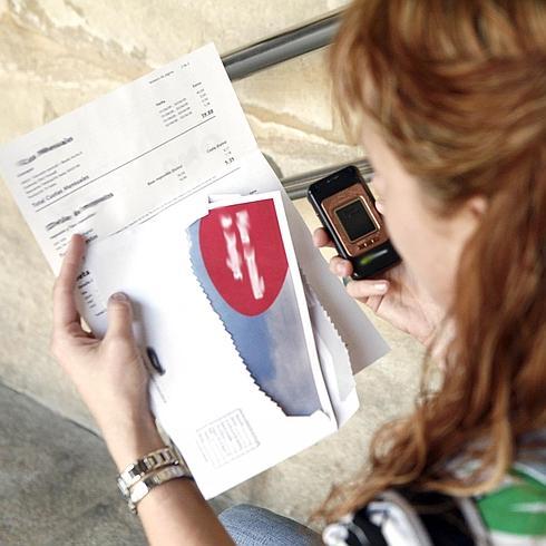 Una mujer consulta una factura telefónica.