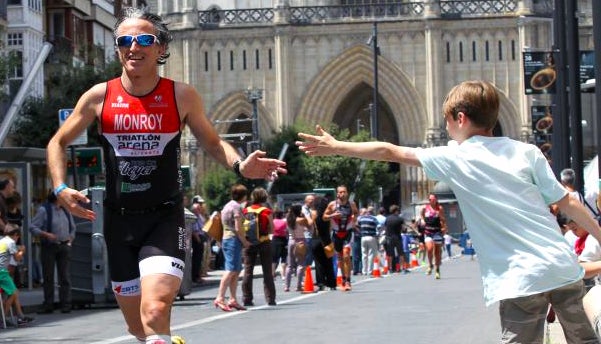Un triatleta saluda a un niño en la calle Prado de Vitoria. 