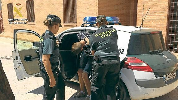 Agentes de la Guardia Civil introducen en el coche patrulla al joven detenido en Calahorra.