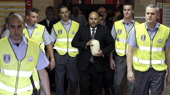 Salida en manos de un trabajador de la funerario Parcesa de las cenizas del misionero Miguel Pajares.