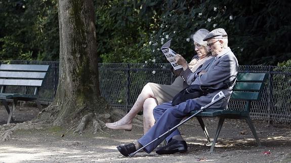 Un matrimonio descansa en el banco de un parque.