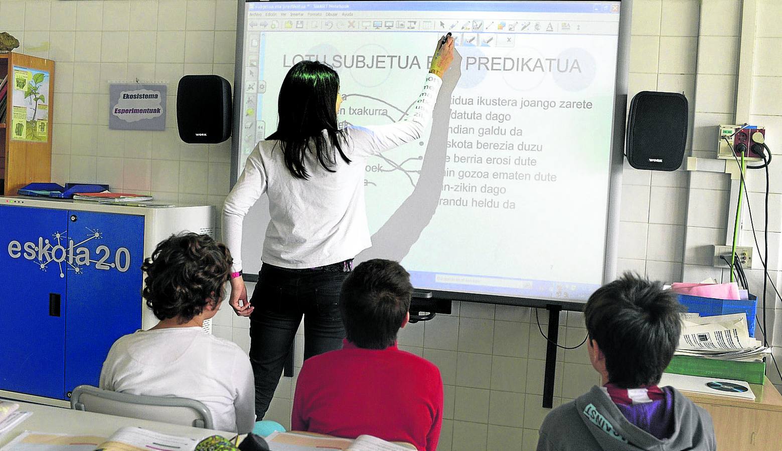 Una profesora imparte la lección a sus alumnos.