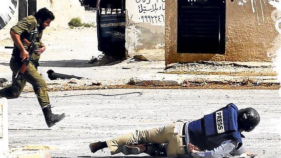 Un reportero cae al suelo entre los disparos de francotiradores en la ciudad siria de Maalula.