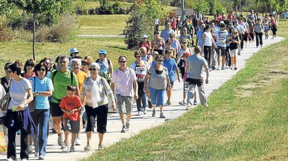Decenas de ciudadanos caminan por Salburua en la segunda edición de la Marcha Familiar Green. 