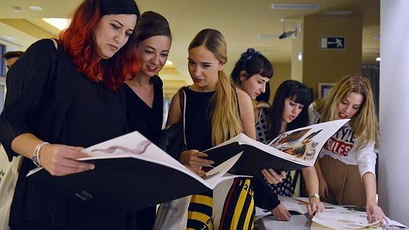 Alumnas de Art&Fashion revisan sus bocetos.