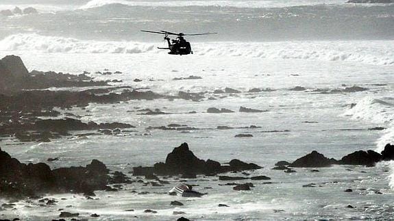 Un helicóptero sobrevuela la embarcación, encallada en la playa de Barrika.