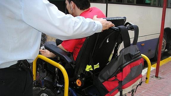 Una persona con movilidad reducida accede a un autocar. 
