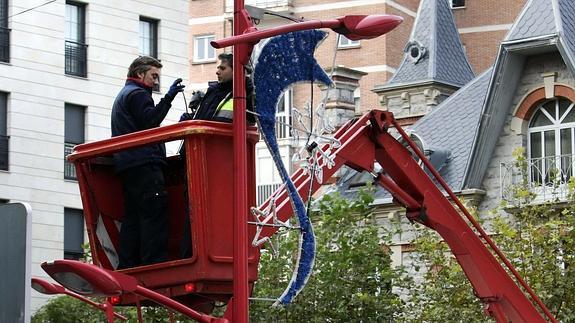 Trabajadores municipales, en una de las farolas de La Estación. 