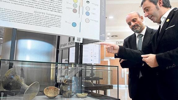 El comisario de la muestra, Josep Mares, enseña a Manu Pereira, del grupo Funeuskadi, varios objetos funerarios de la Edad del Bronce.