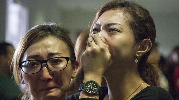 Familiares de personas que viajan en el avión lloran su desaparición.