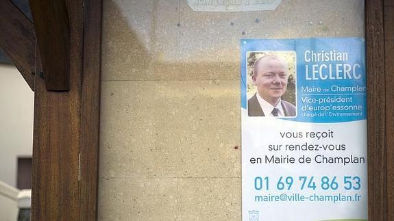 Imagen de un comercio de Champlan que muestra un cartel con el rostro de su alcalde, Christian Leclerc.