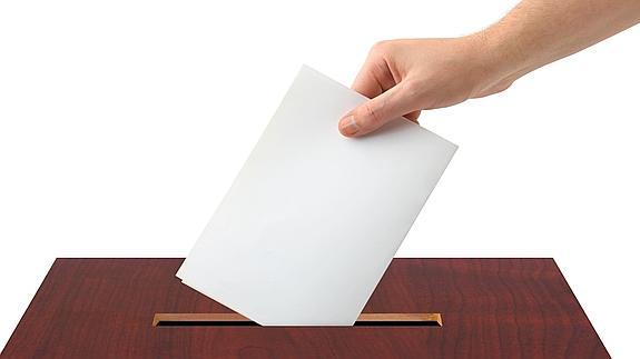 Un votante deposita su papeleta en una urna.