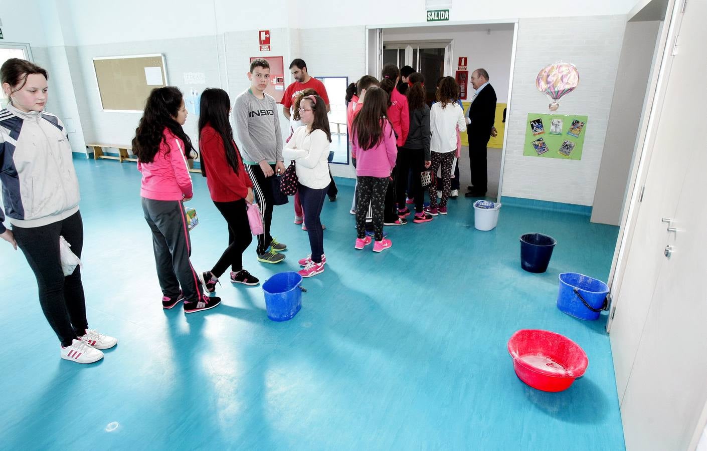 Varios cubos repartidos por el gimnasio recogen las goteras de una cubierta que sufrió más daños durante el temporal de nieve. 