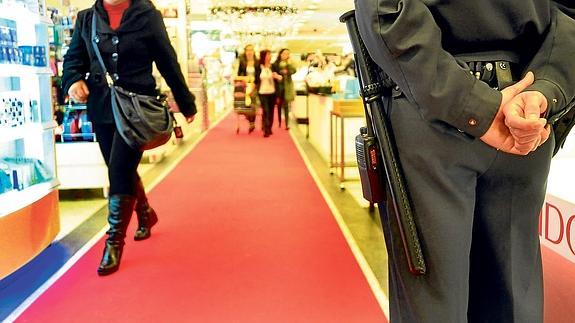 Un guarda de seguridad observa a los clientes en un centro comercial.