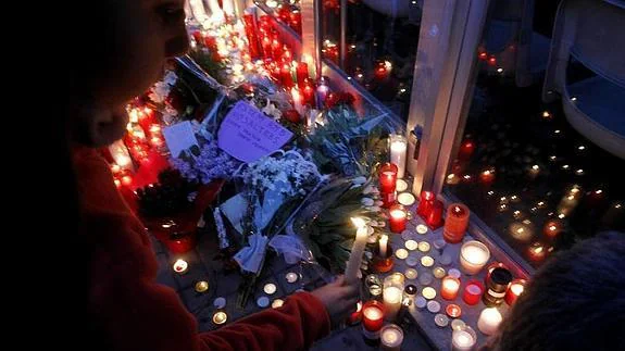 Varias personas depositan flores y velas a las puertas del Instituto de Educación Secundaria Joan Fuster 