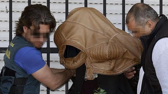 Efectivos de la Guardia Civil, junto al detenido, tras el registro en la casa.