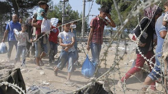 Refugiados cruzan la frontera entre Macedonia y Grecia, cerca de la ciudad de Gevgelija, Macedonia, hoy. 