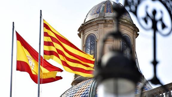 La bandera española y la senyera ondean junto al Palau de la Generalitat.