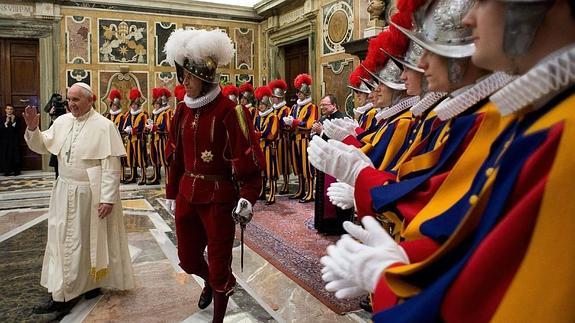 El Papa atraviesa la Sala Clementina rodeado de la Guardia Suiza.