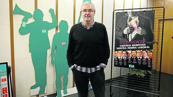 Adolfo Muñoz, ‘Txiki’, en la sede del sindicato, ante el polémico cartel de la última campaña de denuncia de ELA contra algunos grandes empresarios. 