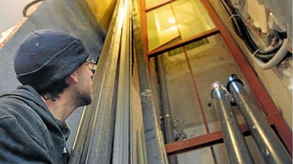 Un hombre observa las obras de instalación de un ascensor en un edificio.