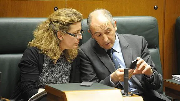 El portavoz del Gobierno vasco, Josu Erkoreka, muestra su teléfono movil a la consejera de Medio Ambiente y Transportes, Ana Oregi.