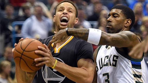 Stephen Curry busca la canasta ante el defensopr de Milwaukee Bucks O.J. Mayo. 