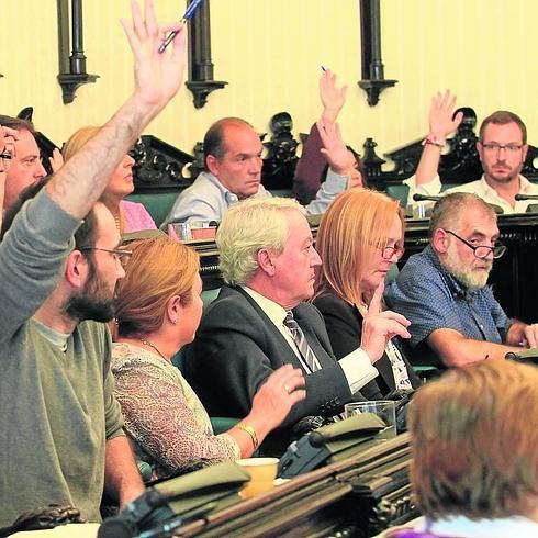 Concejales de diferentes partidos votan en un pleno. 